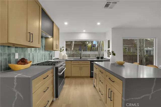 a kitchen with granite countertop a sink stove and cabinets