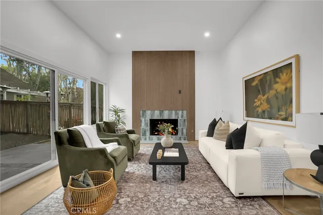 a living room with furniture a large window and a fireplace