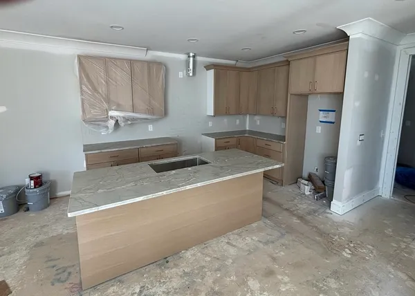 a room with a sink cabinets and a wooden floor