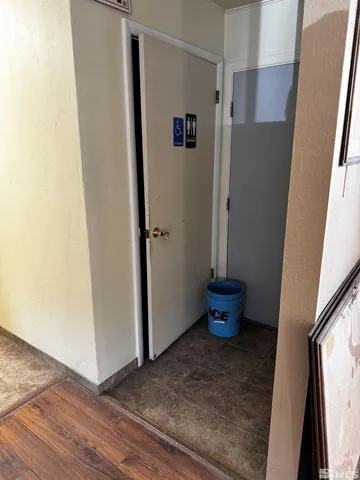 a view of a hallway with wooden floor and a potted plant