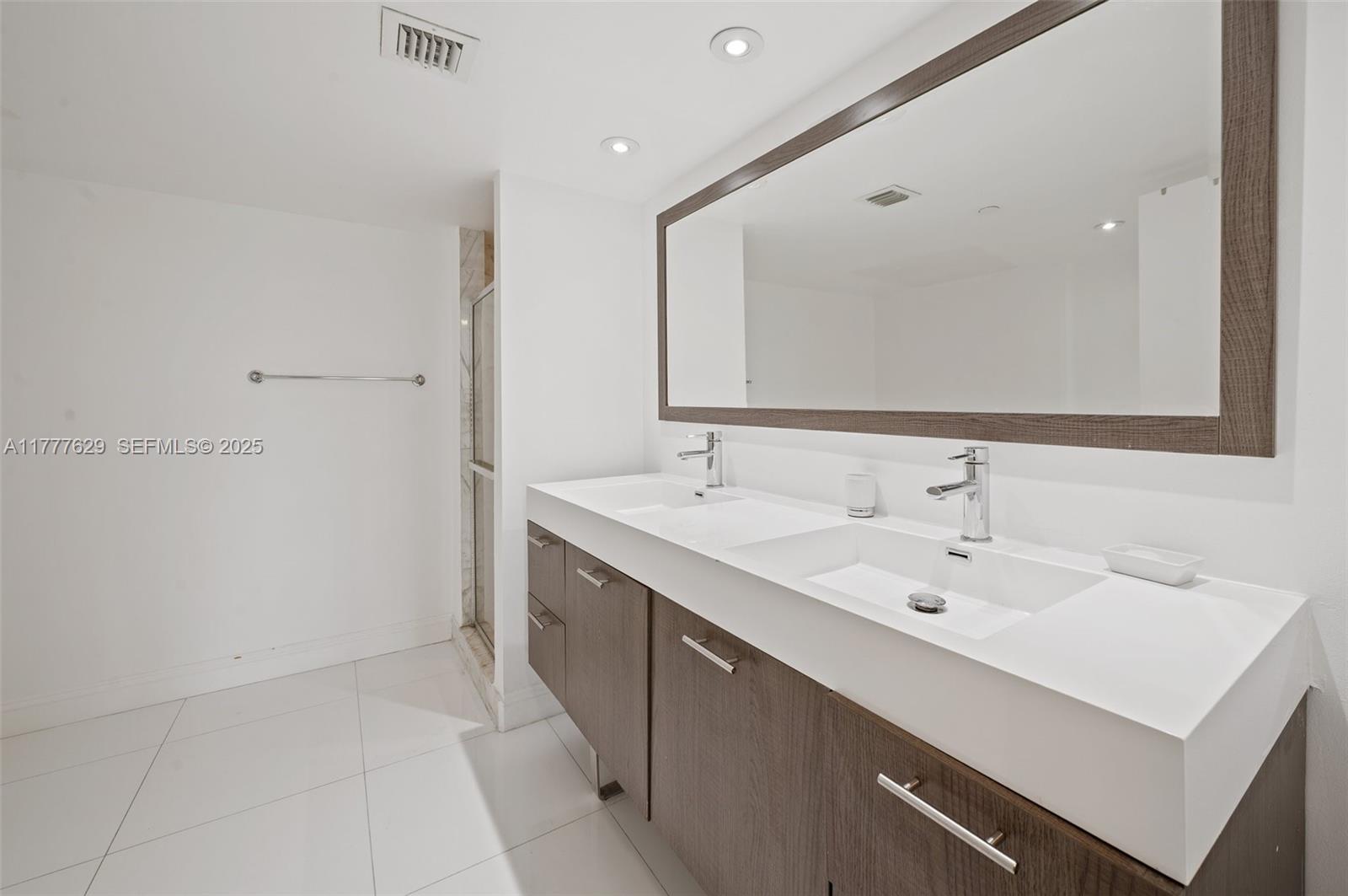 2000 Towerside Terrace, Unit 805 Miami, FL 33138 - Photo 17 of 47 a bathroom with a sink and a mirror