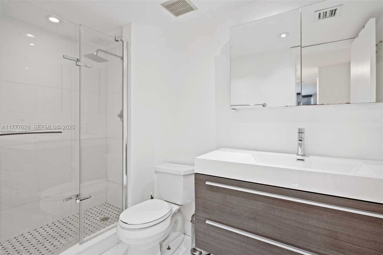 2000 Towerside Terrace, Unit 805 Miami, FL 33138 - Photo 22 of 47 a bathroom with a sink a toilet and a shower