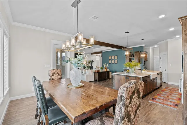 a view of a dining room and livingroom with furniture wooden floor a chandelier