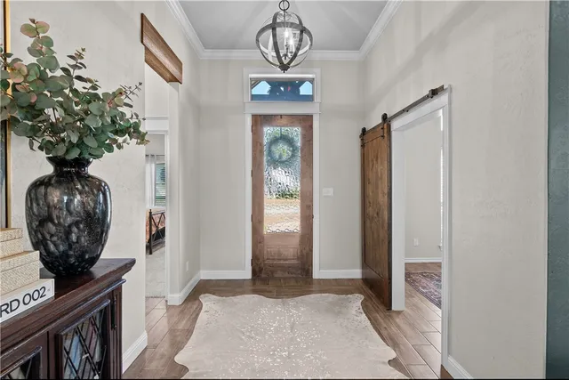 a view of a hallway with wooden floor a chandelier and entryway