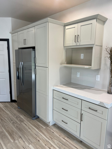 160 200 West Henefer, UT 84033 - Photo 8 of 25 Kitchen featuring light-toned cabinetry with dark hardware, a built-in stainless steel refrigerator, and wood-finish flooring