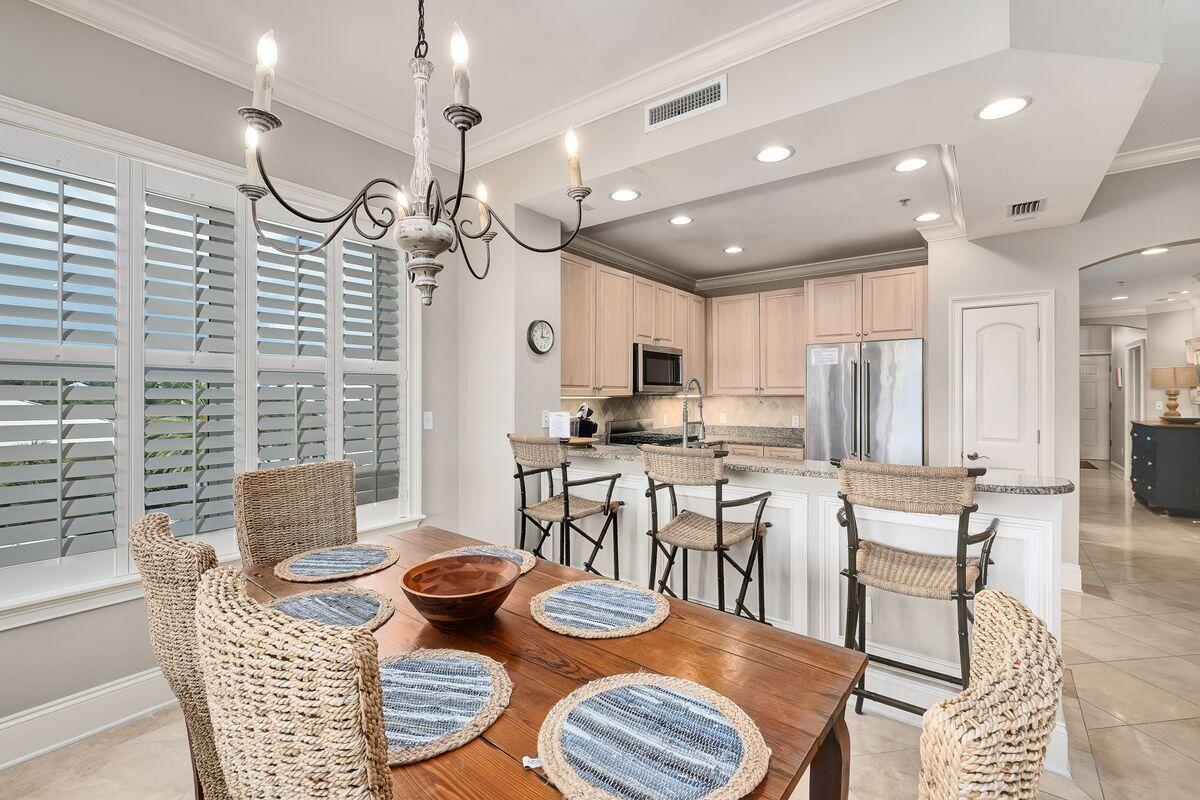 2421 West County Highway 30A, Unit E305 Santa Rosa Beach, FL 32459 - Photo 6 of 39 a kitchen with stainless steel appliances kitchen island granite countertop a dining table chairs and a refrigerator