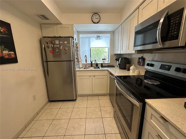 a kitchen with a refrigerator a stove a microwave and cabinets
