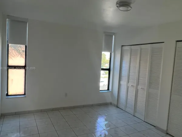 an empty room with windows and closet