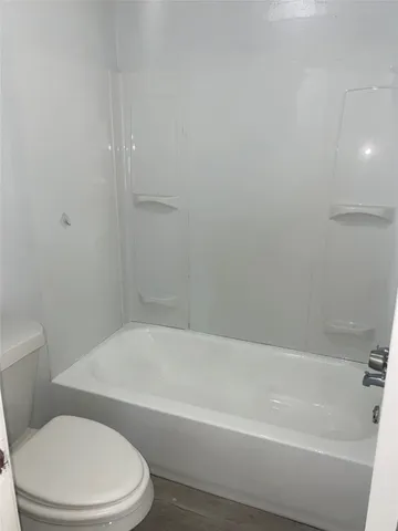 a white toilet and tub sitting next to a bathroom sink