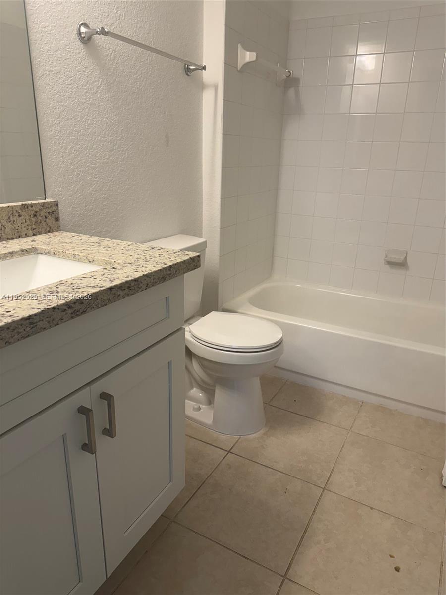 15410 Southwest 284th Street, Unit 8104 Homestead, FL 33033 - Photo 15 of 25 a bathroom with a granite countertop toilet a sink and a bathtub