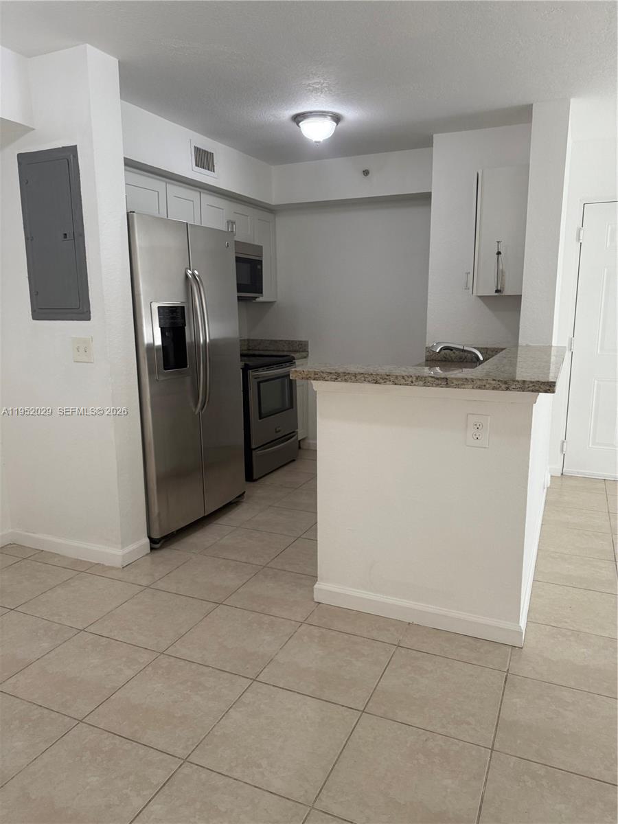 15410 Southwest 284th Street, Unit 8104 Homestead, FL 33033 - Photo 9 of 25 a kitchen with stainless steel appliances a refrigerator sink and stove