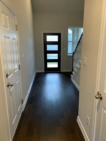 a view of a hallway with wooden floor and stairs