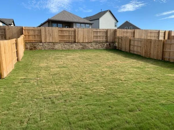 a view of a house with wooden fence
