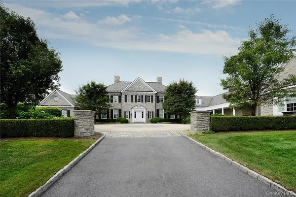 a front view of a house with a garden and tree