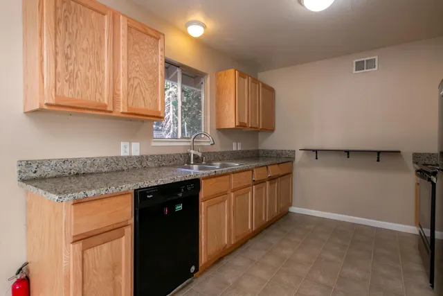 a kitchen with granite countertop a sink and cabinets