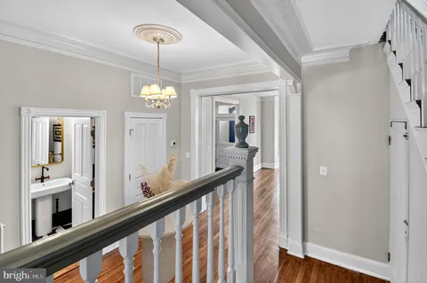 a view of a hallway with windows and chandelier