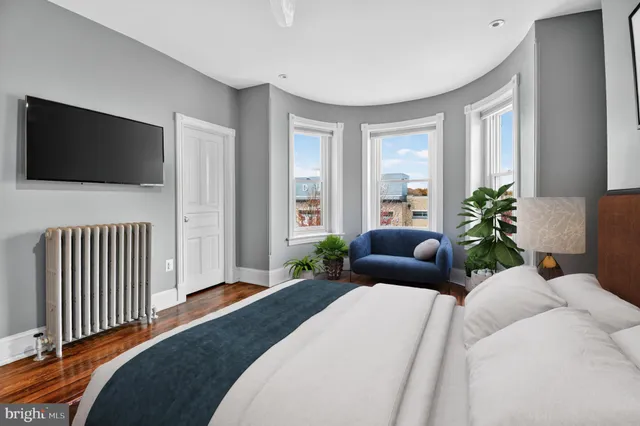 a bedroom with a large bed and a flat screen tv