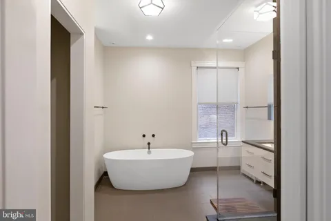 a bathroom with a white tub shower and sink