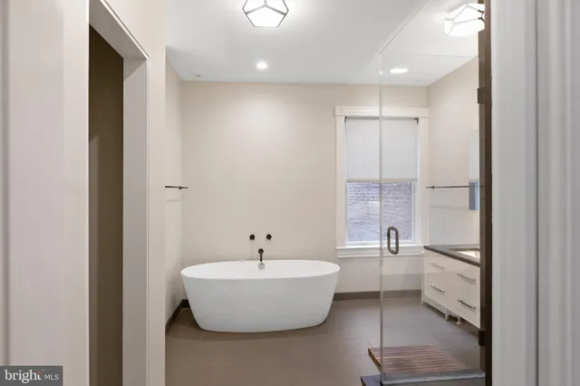 a bathroom with a white tub shower and sink