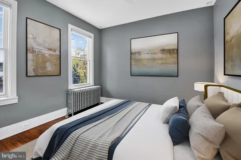 a bedroom with a bed and wooden floor