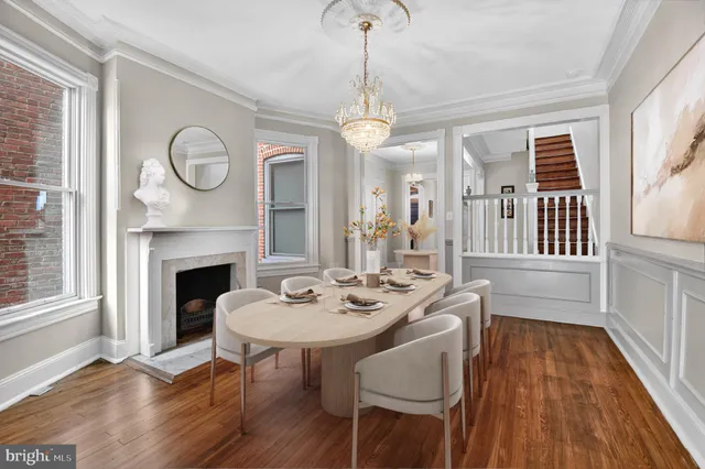 a dining room with wooden floor a chandelier a wooden table and chairs