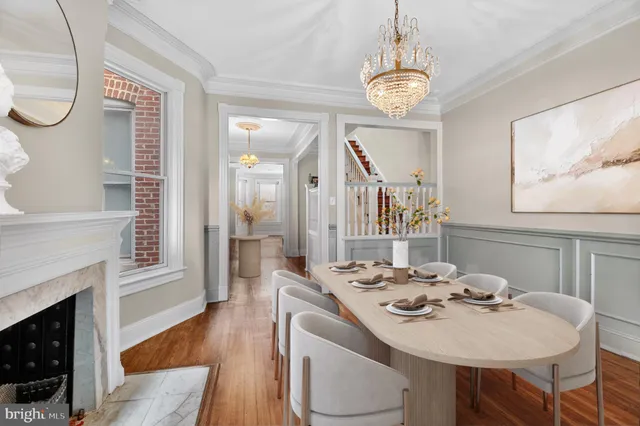 a view of a dining room with furniture a chandelier and wooden floor