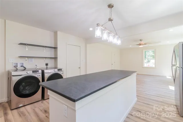 a kitchen with stainless steel appliances granite countertop a sink a stove and a wooden floors