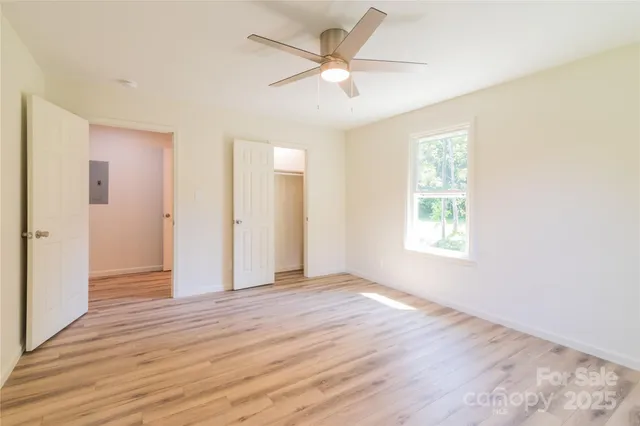 an empty room with wooden floor and windows