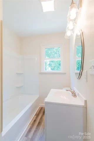 a bathroom with a bathtub a sink and a mirror