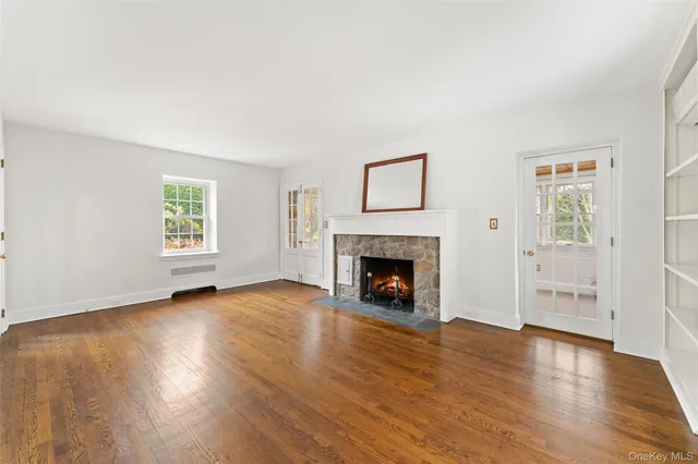 a view of empty room with wooden floor and fireplace