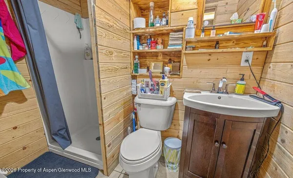 a bathroom with a sink a toilet and shower curtain
