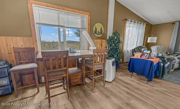 a living room with furniture a large window and wooden floor