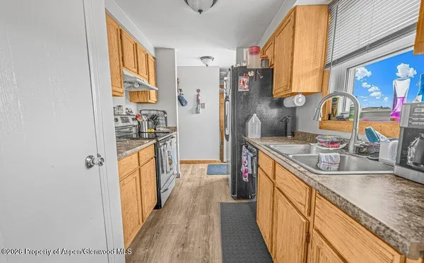 a kitchen with stainless steel appliances granite countertop a sink and a refrigerator