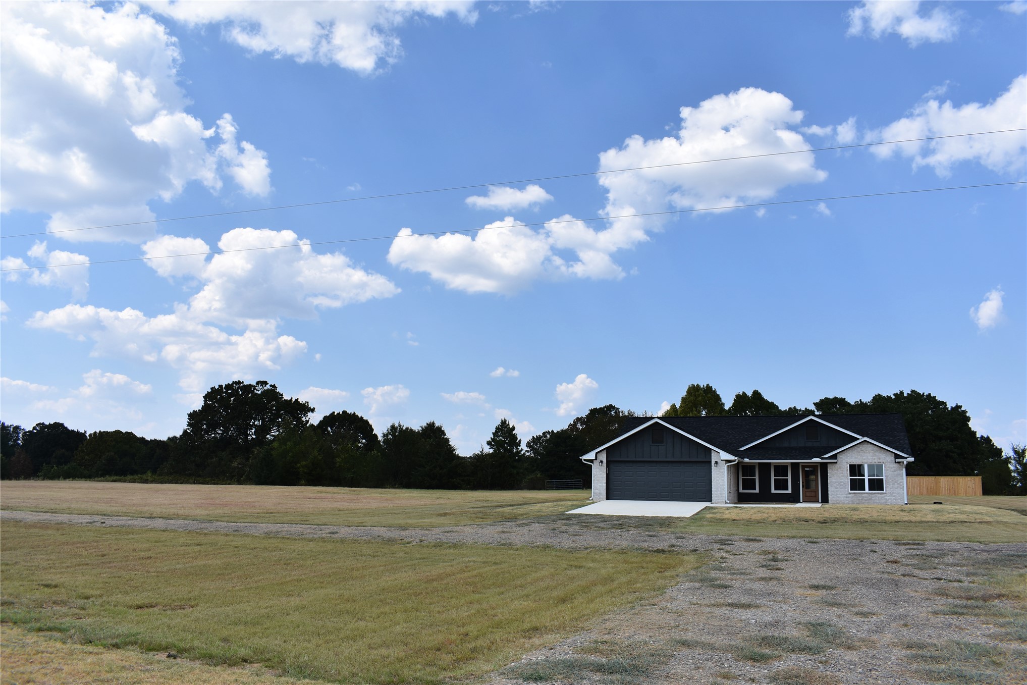 2915 East 2090 Road, Unit LOT 1 Hugo, OK 74743 - Photo 28 of 28 Single-story residence featuring a two-car garage, stone and siding exterior, and a dark shingle roof
