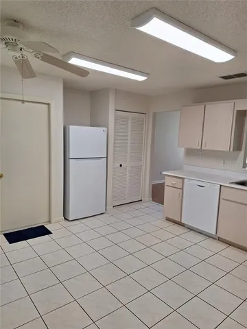 a kitchen with a refrigerator sink and cabinets