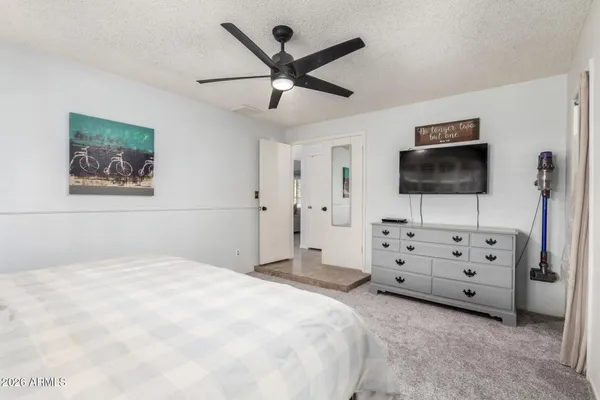 a bedroom with a bed window and a flat screen tv