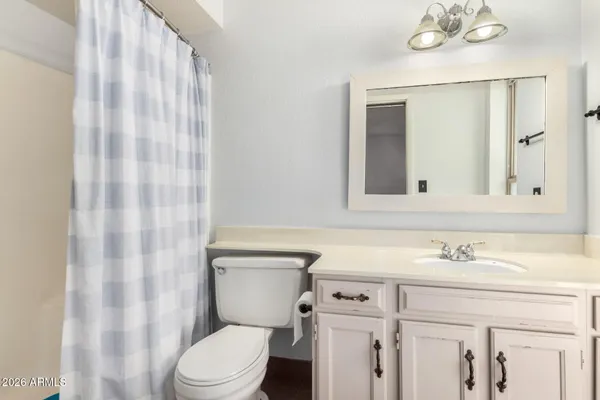 a bathroom with a sink vanity mirror and toilet
