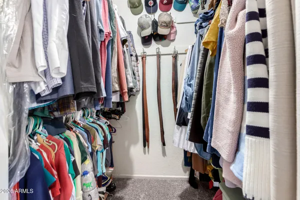 a view of walk in closet with clothes and shoes