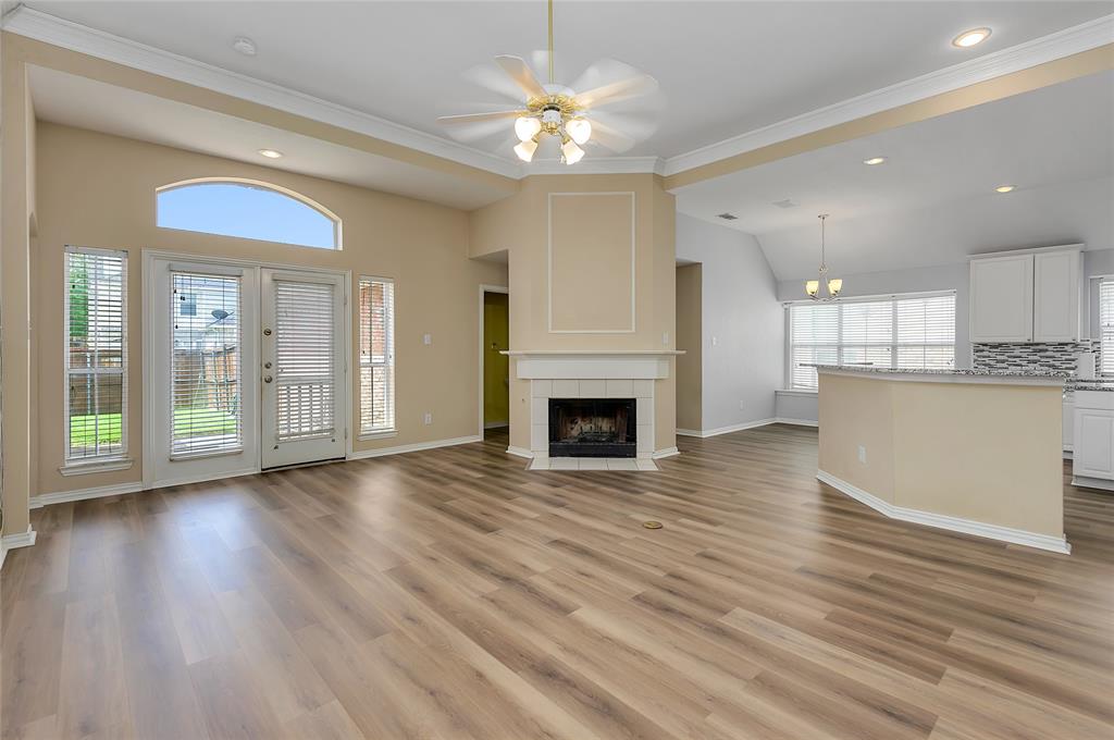 1404 Ranch Hill Drive Irving, TX 75063 - Photo 10 of 31 Open-concept living space featuring wood-finish flooring, a fireplace with a white mantel, and a ceiling fan