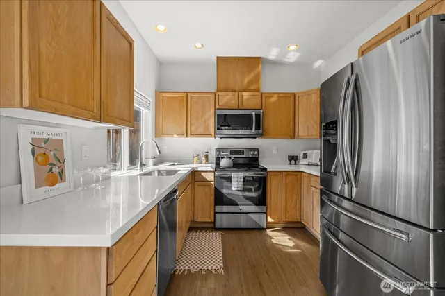 a kitchen with stainless steel appliances a refrigerator sink and stove