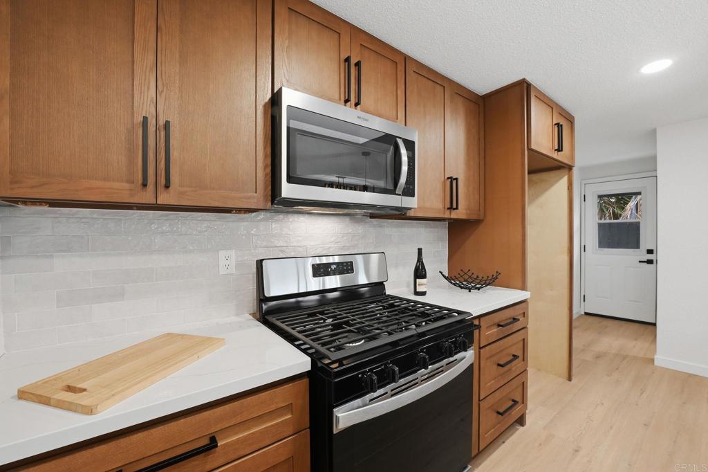 1333 Helix Street Spring Valley, CA 91977 - Photo 19 of 45 a kitchen with stainless steel appliances granite countertop a stove and a microwave