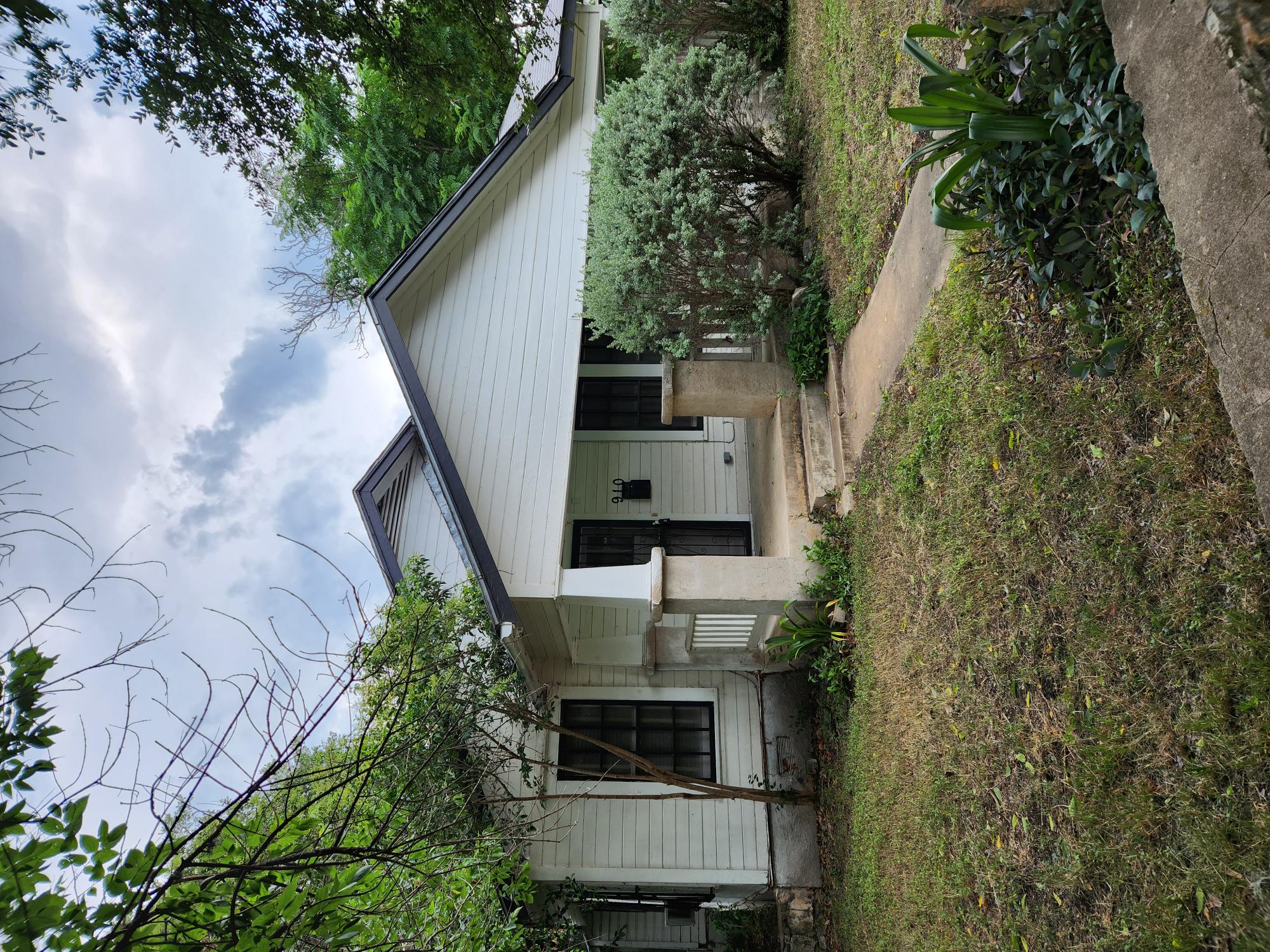 a front view of a house with a garden