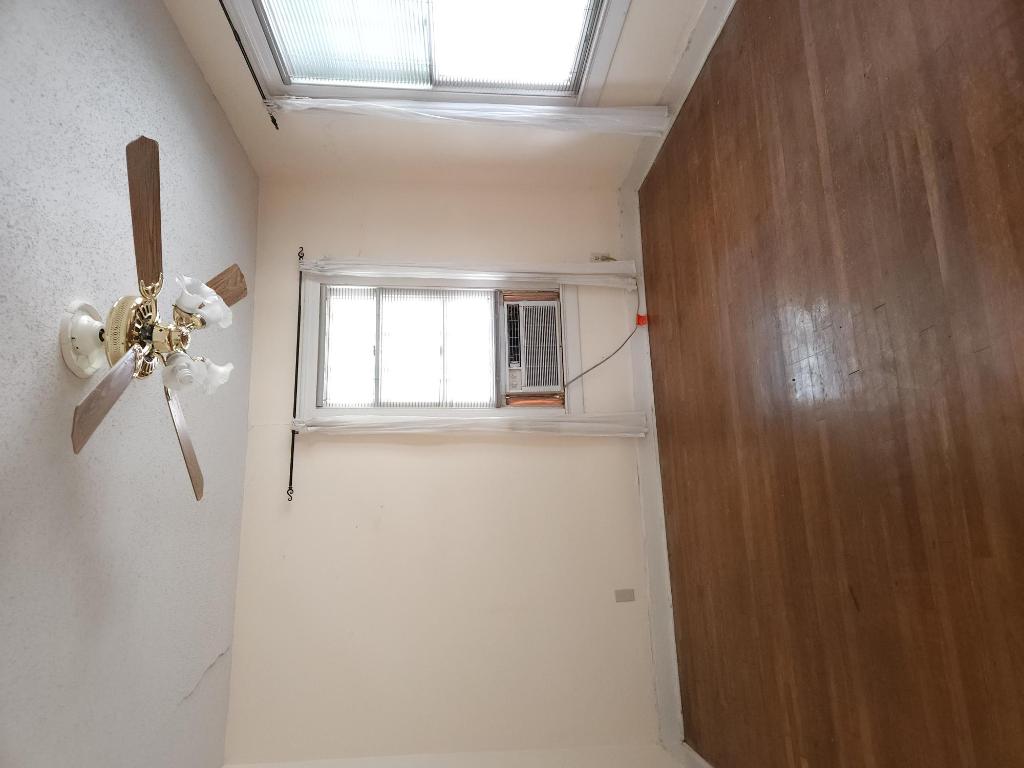 910 East 13th Street Austin, TX 78702 - Photo 7 of 16 an empty room with wooden floor chandelier fan and windows