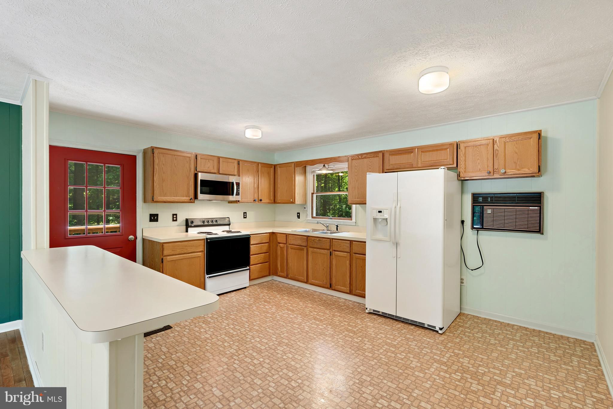 11320 Drogheda Mountain Road Rixeyville, VA 22737 - Photo 3 of 29 a large kitchen with a refrigerator a stove top oven a sink and dishwasher