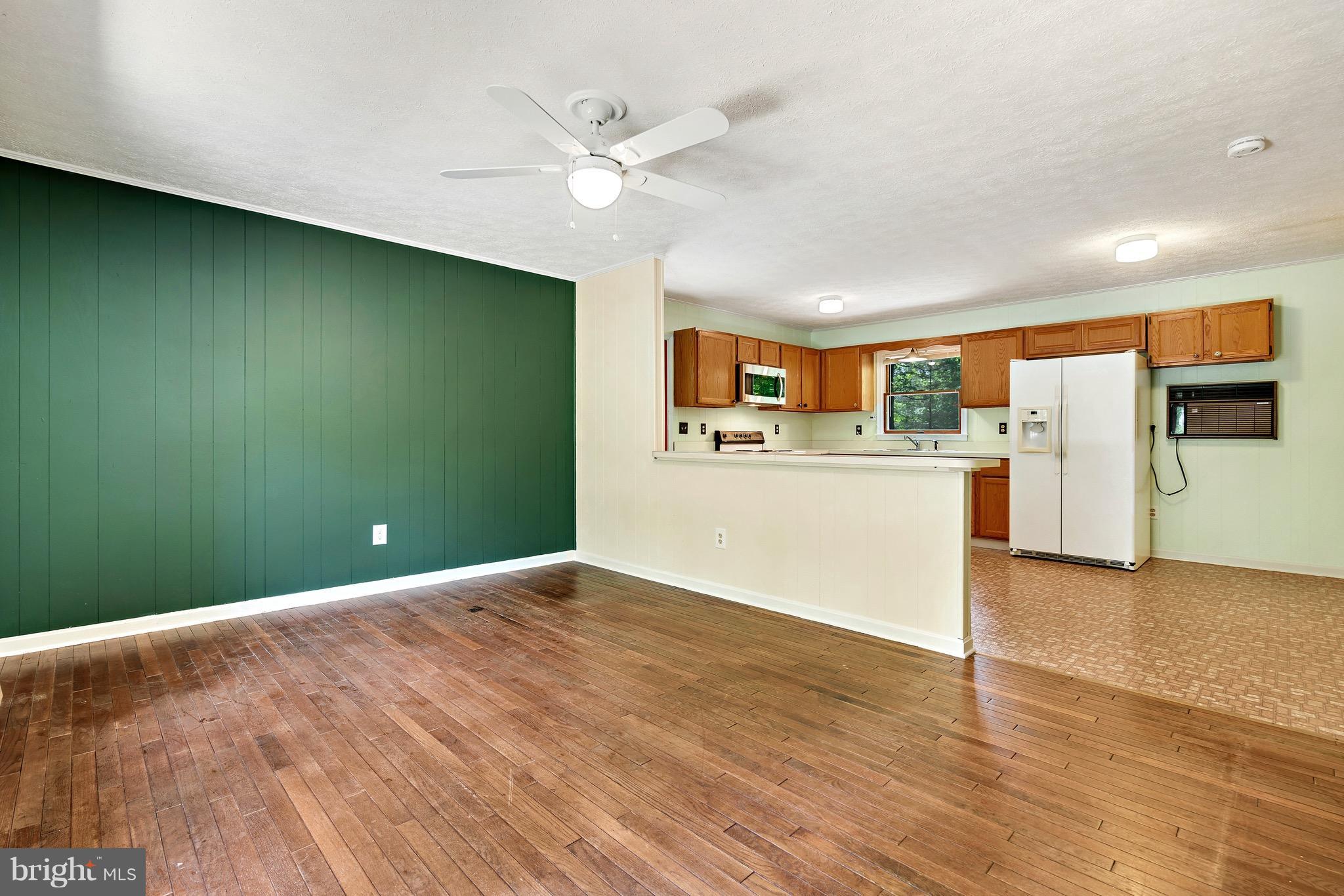 11320 Drogheda Mountain Road Rixeyville, VA 22737 - Photo 4 of 29 a view of a kitchen with a sink a refrigerator a ceiling fan and wooden floor