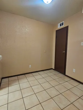 a view of an empty room and chandelier fan