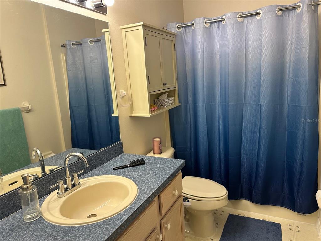 32905 Timberwood Drive Leesburg, FL 34748 - Photo 13 of 27 a bathroom with a granite countertop sink toilet and shower