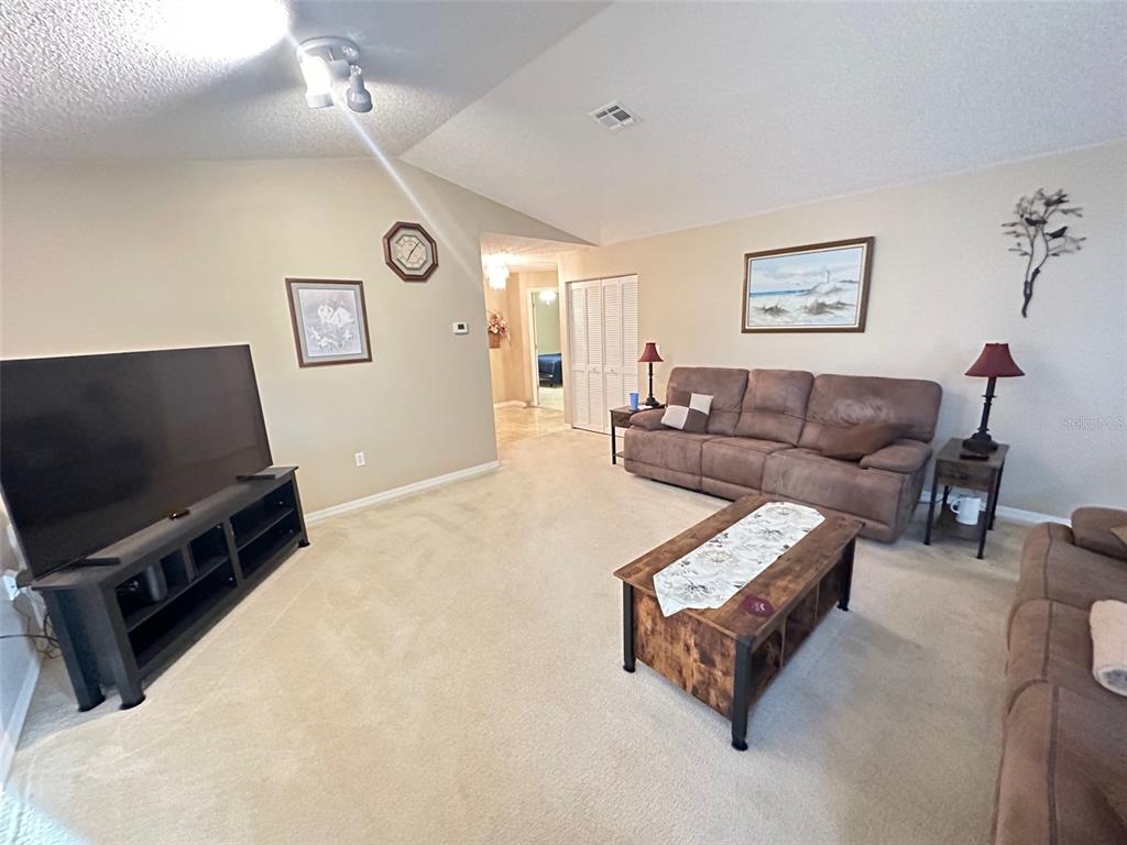 32905 Timberwood Drive Leesburg, FL 34748 - Photo 2 of 27 a living room with furniture and a flat screen tv