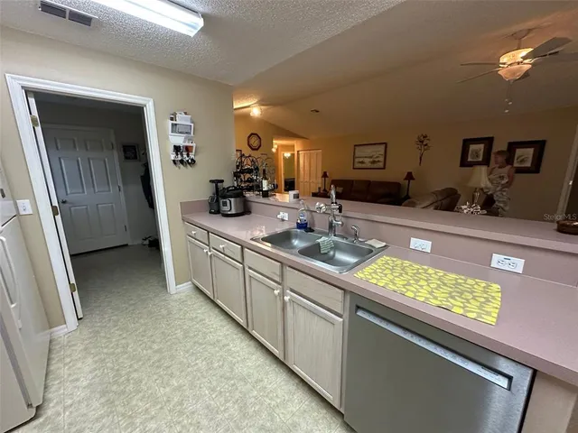 a kitchen with sink and view of living room