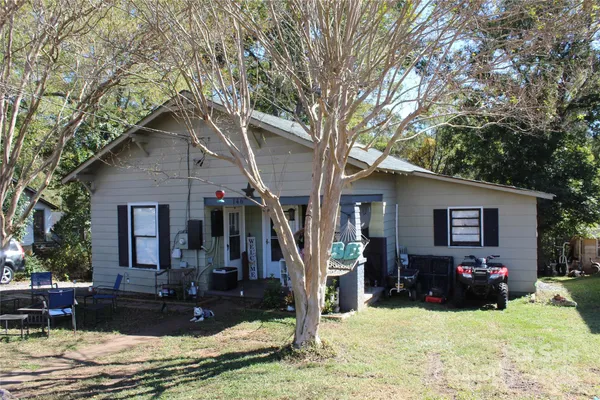 a view of a house with yard and trees in the background